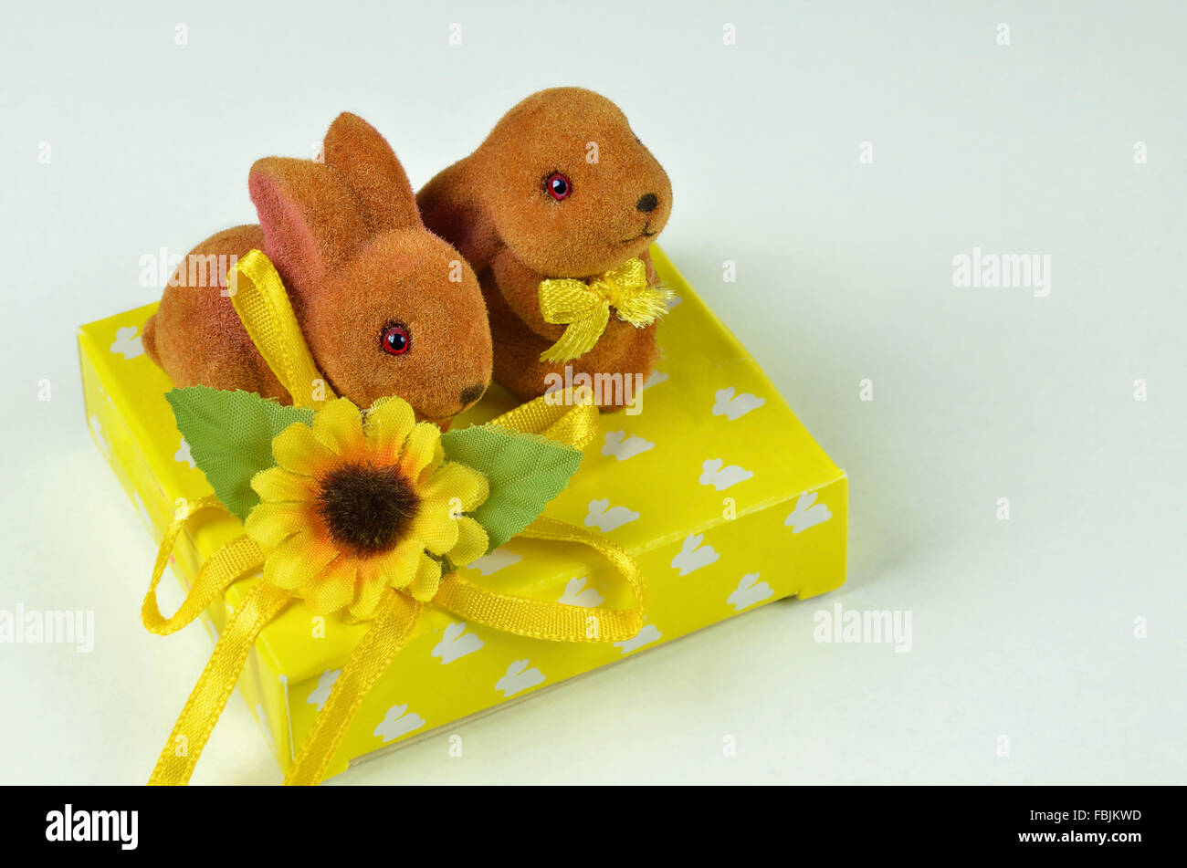 close up of two Easter bunnies on a yellow parcel, horizontal, macro, detail, negative space, copy space Stock Photo
