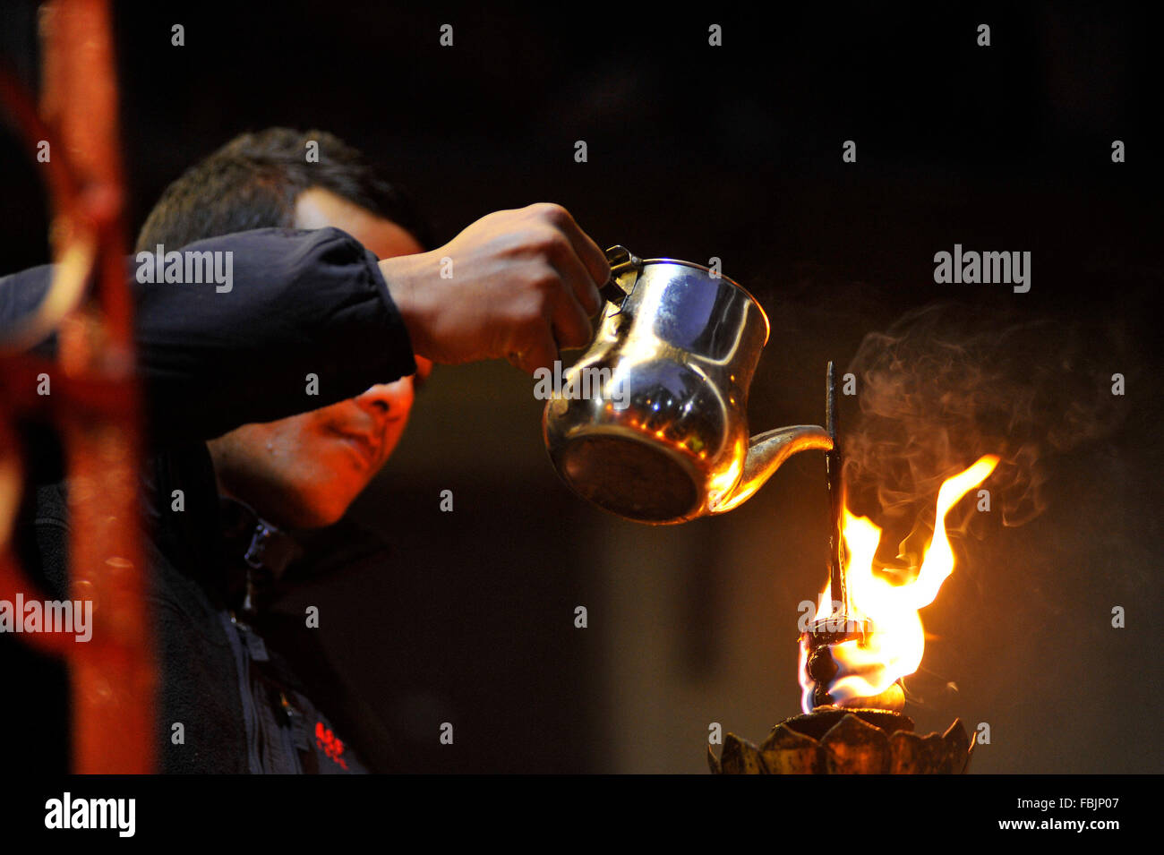 Kathmandu, Nepal. 17th Jan, 2016. Nepalese Priests refilling oil in oil