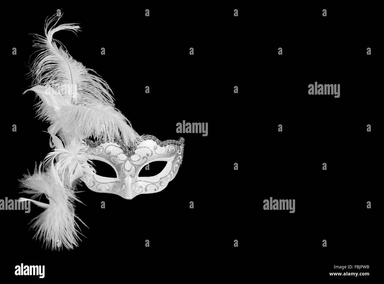 white venetian carnival mask with feathers on black background with free space for text. Stock Photo