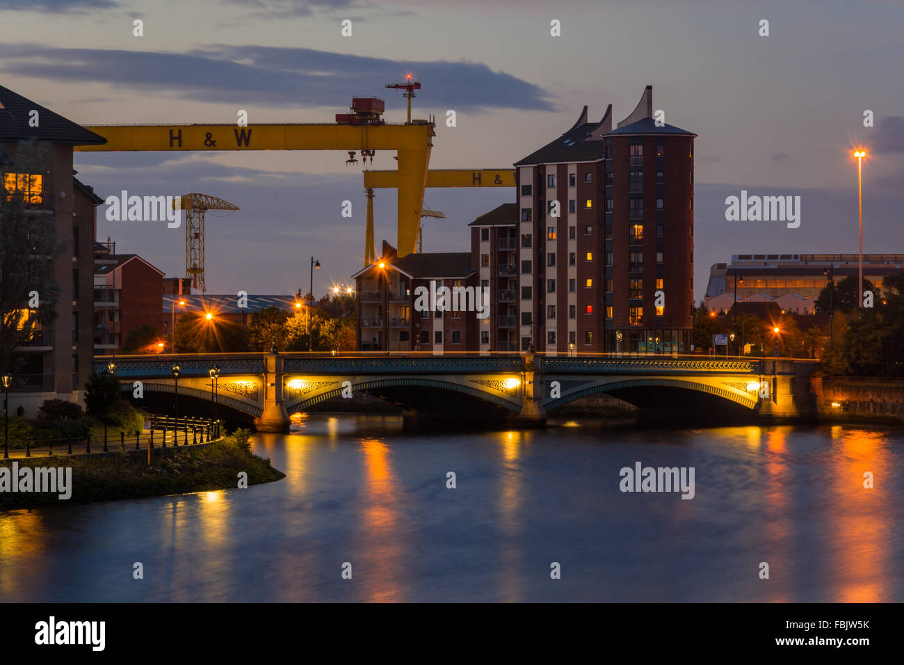 A long exposure photograph taken at the River Lagan looking towards the Albertbridge in Belfast with the H&W in backdrop. Stock Photo