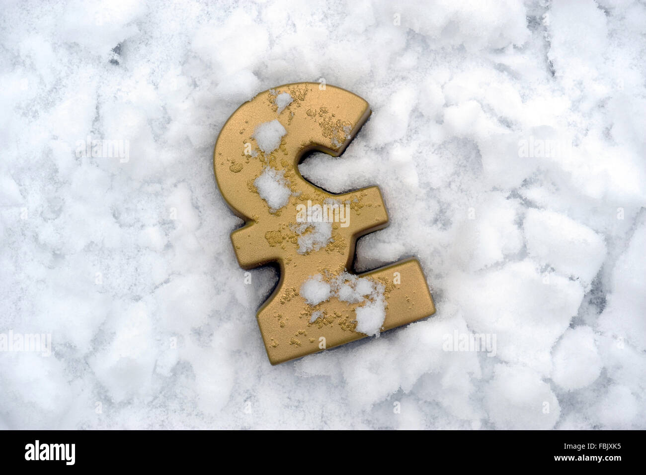 POUND SIGN IN ICE AND SNOW RE COLD WEATHER PAYMENT HOME INSULATION RISING FUEL COSTS HEATING ICE STAYING WARM GAS BILL UK Stock Photo