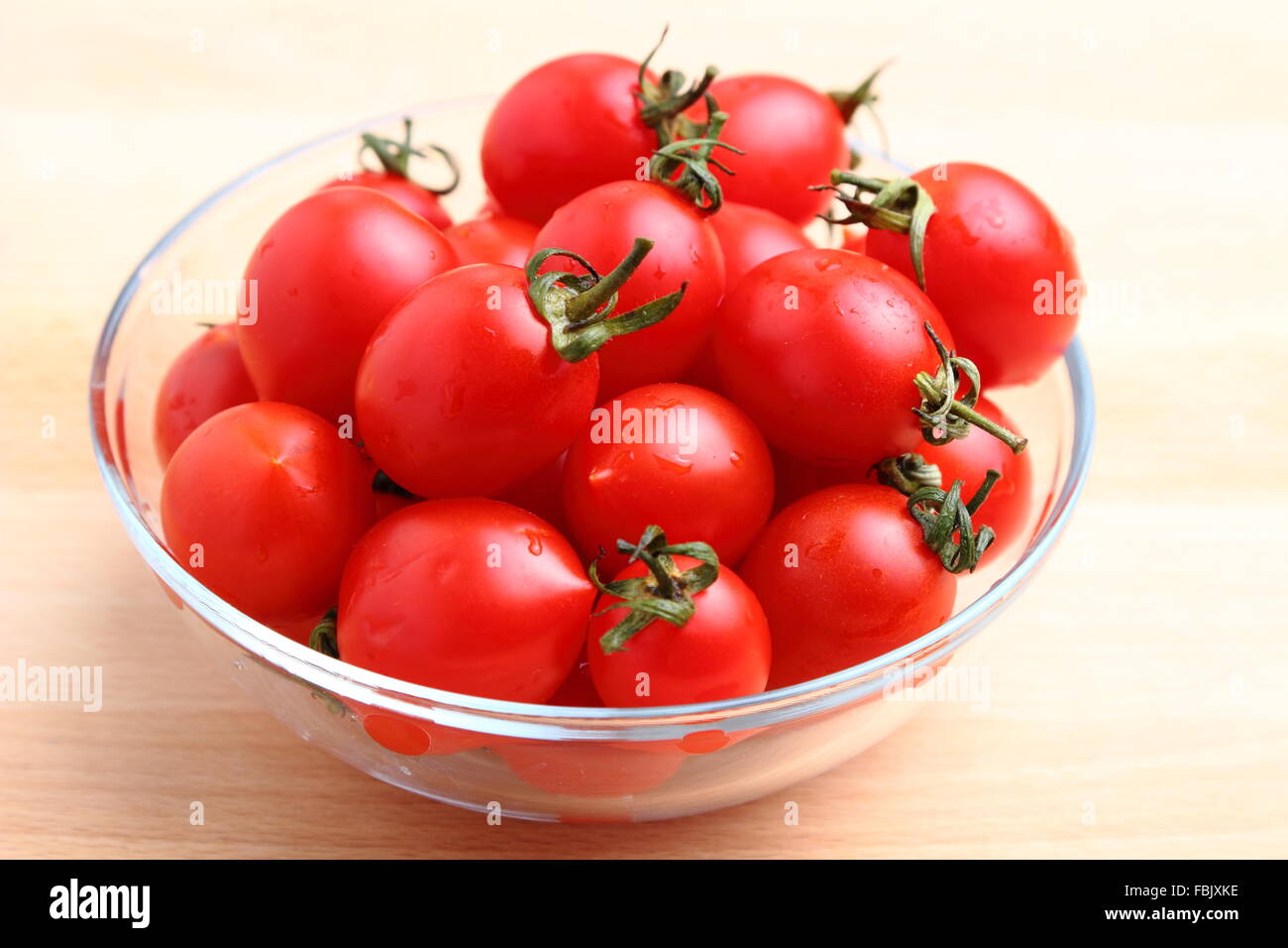 Organic fresh cherry tomatoes in a glass bowl Stock Photo