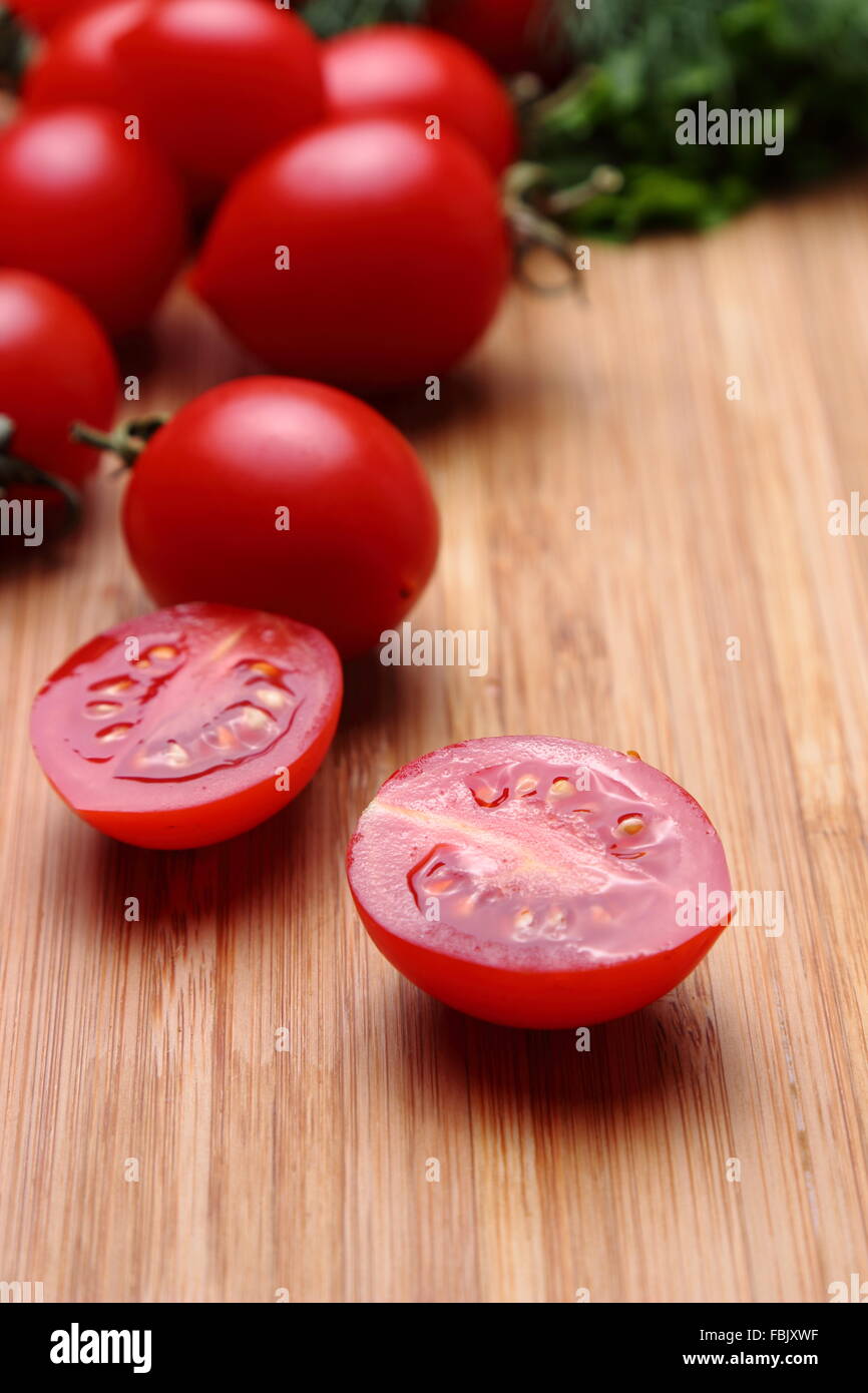 Ripe red tomatoes with dill on the wooden background Stock Photo