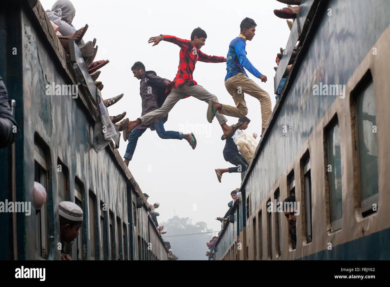 DHAKA, BANGLADESH 10th January 2016: People jumping over crowded train they attend the Akheri Munajat concluding prayers on the third day of Biswa Ijtema, the second largest Muslim congregation after the Hajj, at Tongi Railway station in Tongi 20 km from Dhaka on January 10, 2016. Around two million Muslims from Bangladesh and abroad observed the three-day congregation with prayers on the banks of the Turag River. Stock Photo