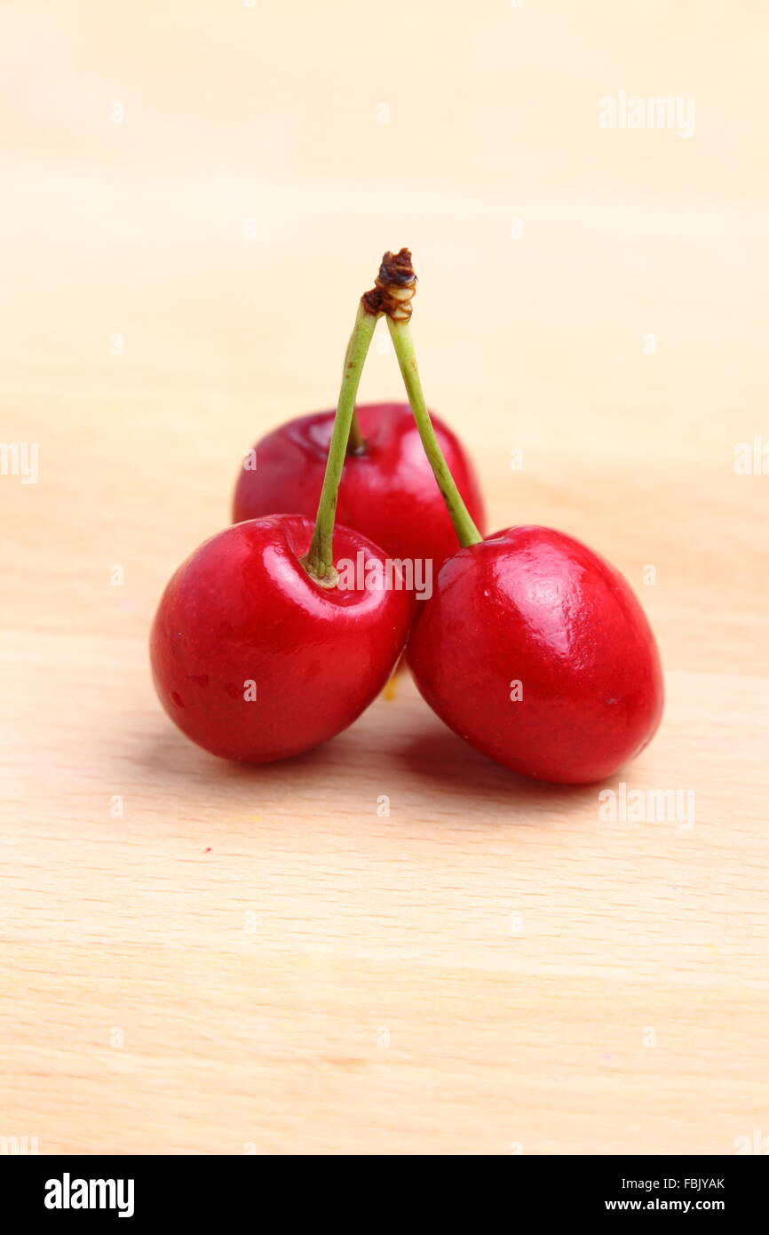 Three natural red cherries with stem Stock Photo