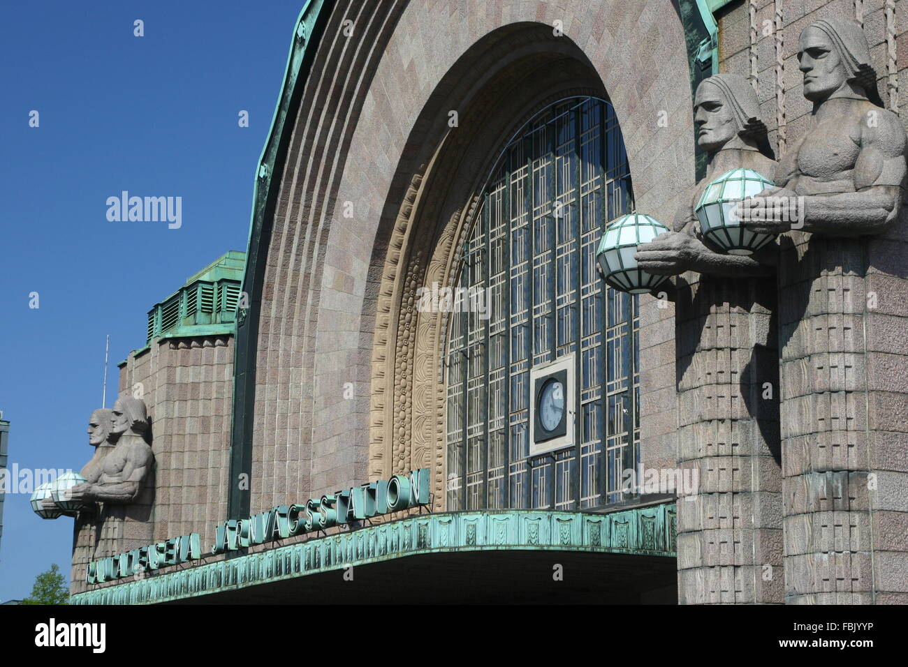 Helsinki Railway station & VR statues Lyhdynkantajat & Bell Tower, Finland Stock Photo