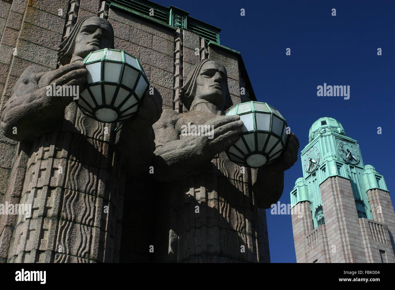 Helsinki Railway station & VR statues Lyhdynkantajat & Bell Tower, Finland Stock Photo