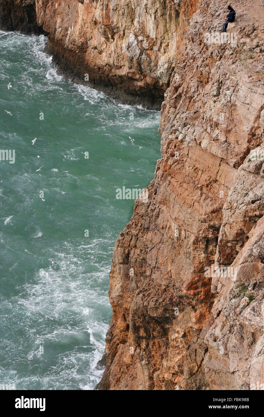 Severe dramatic seascape with fisherman in Cape Saint Vicent cliffs, Portugal Stock Photo