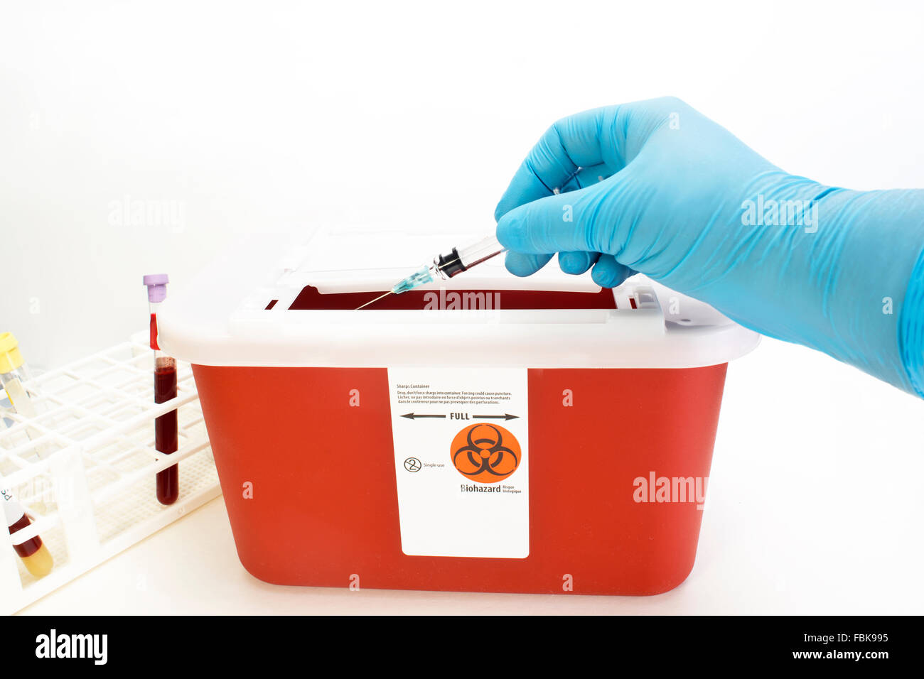 Technician drops syringe into sharps container Stock Photo Alamy