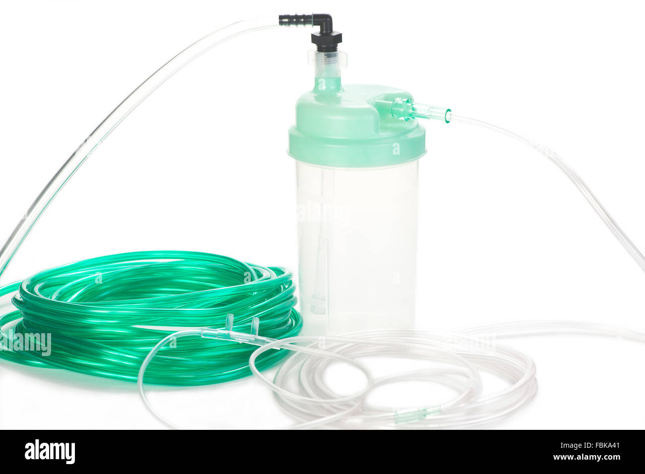 Oxygen therapy system humidifier bottle with green oxygen tubing and nasal cannula. Stock Photo