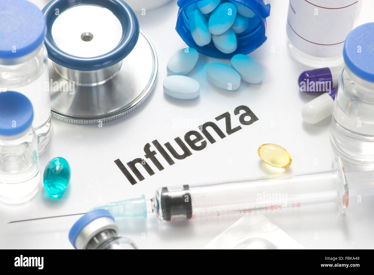 Influenza concept photo with pills, syringe, vials, and stethoscope. Stock Photo