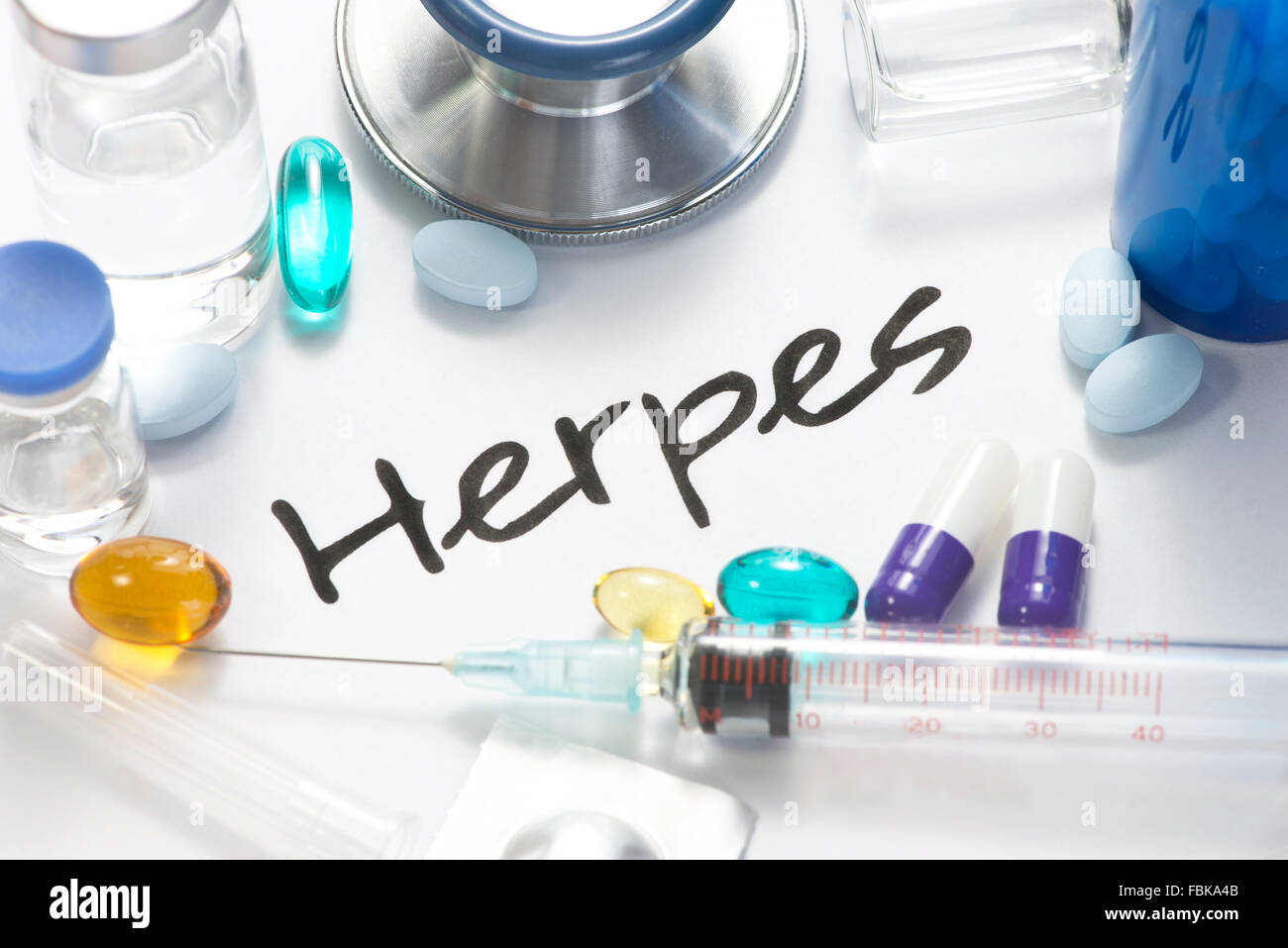 Herpes virus concept photo with pills, vials, and stethoscope. Stock Photo