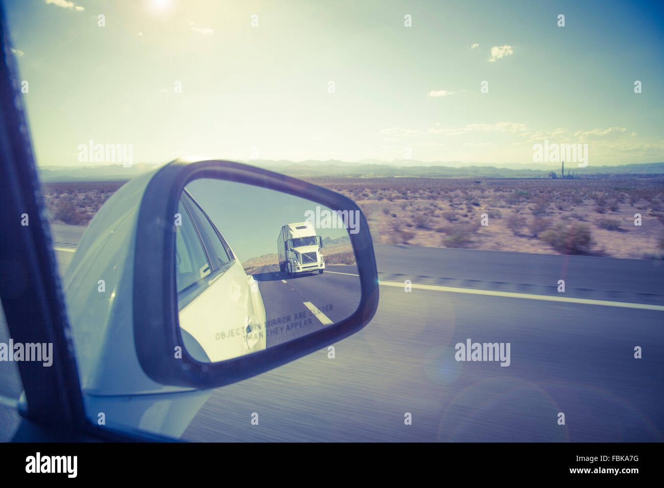 Reflection of large truck in wing mirror on US freeway. Stock Photo
