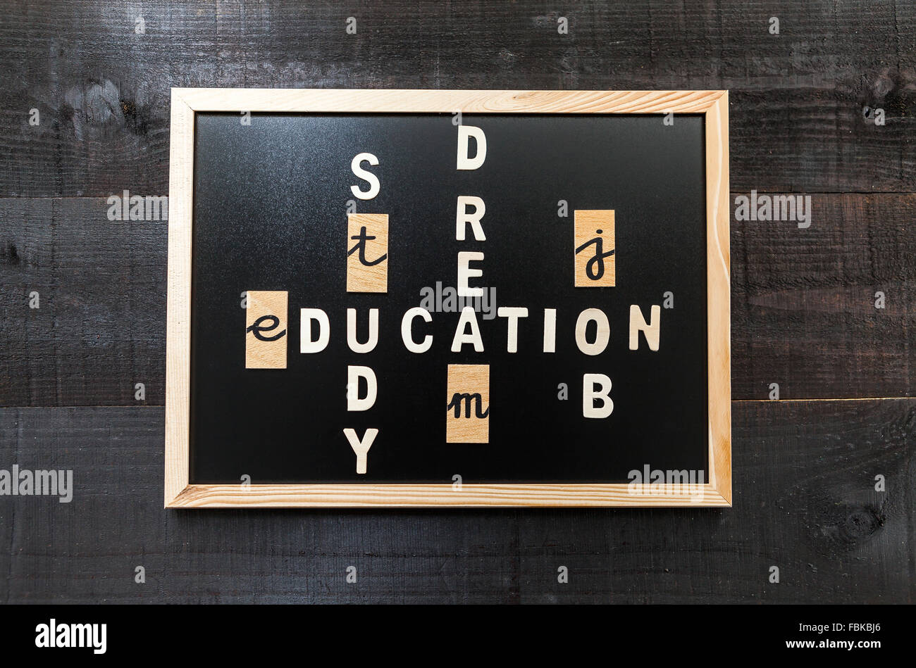 Wooden letters on chalkboard and wood background with a concept message about education concept Stock Photo