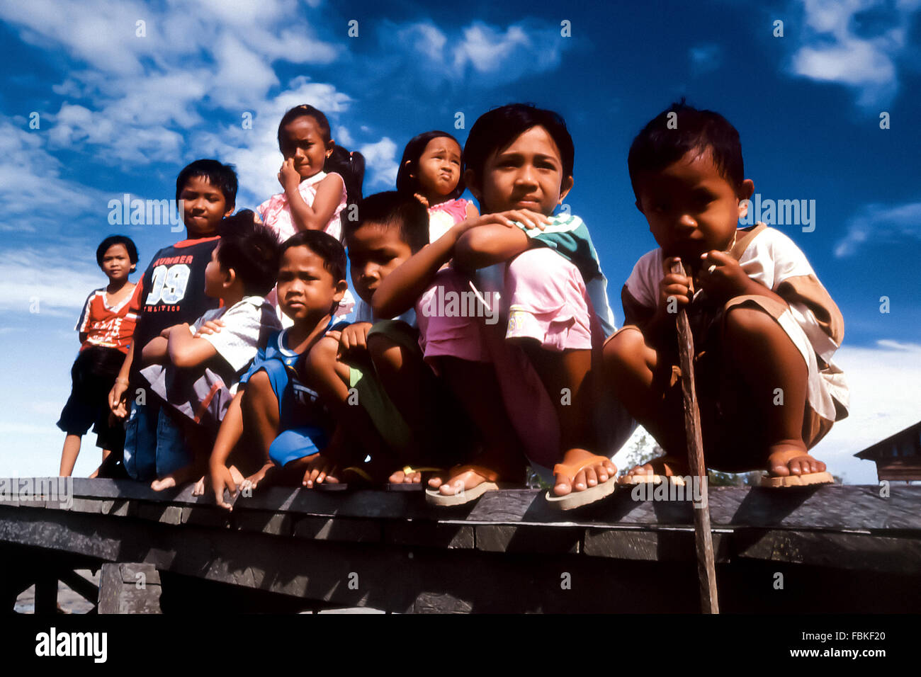 Portrait of children as they are grouping on a jetty in the coastal village of Tanjung Batu in Berau, East Kalimantan, Indonesia. Stock Photo