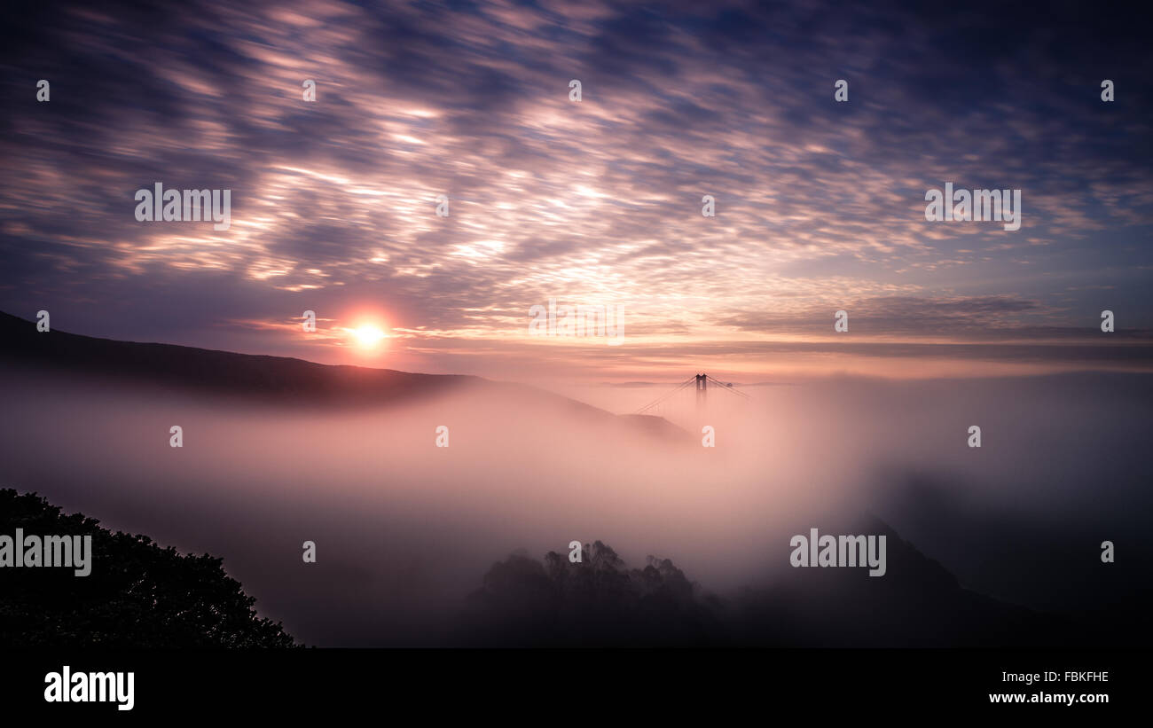 Beautiful sunrise with the fog enveloping the mountains and the Golden Gate Bridge Stock Photo