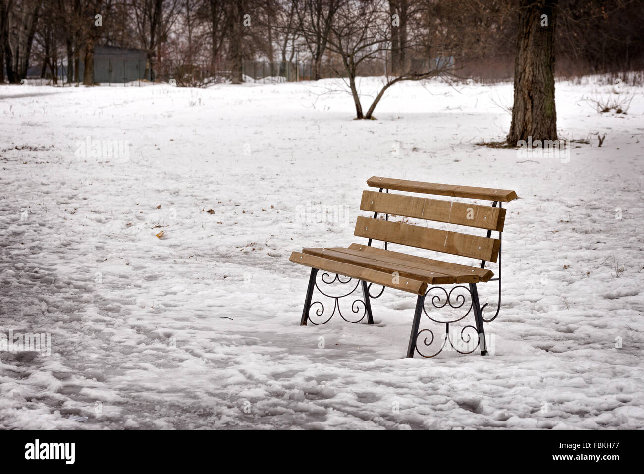A lonely bench in the park covered by snow in winter, Kiev, Ukraine ...
