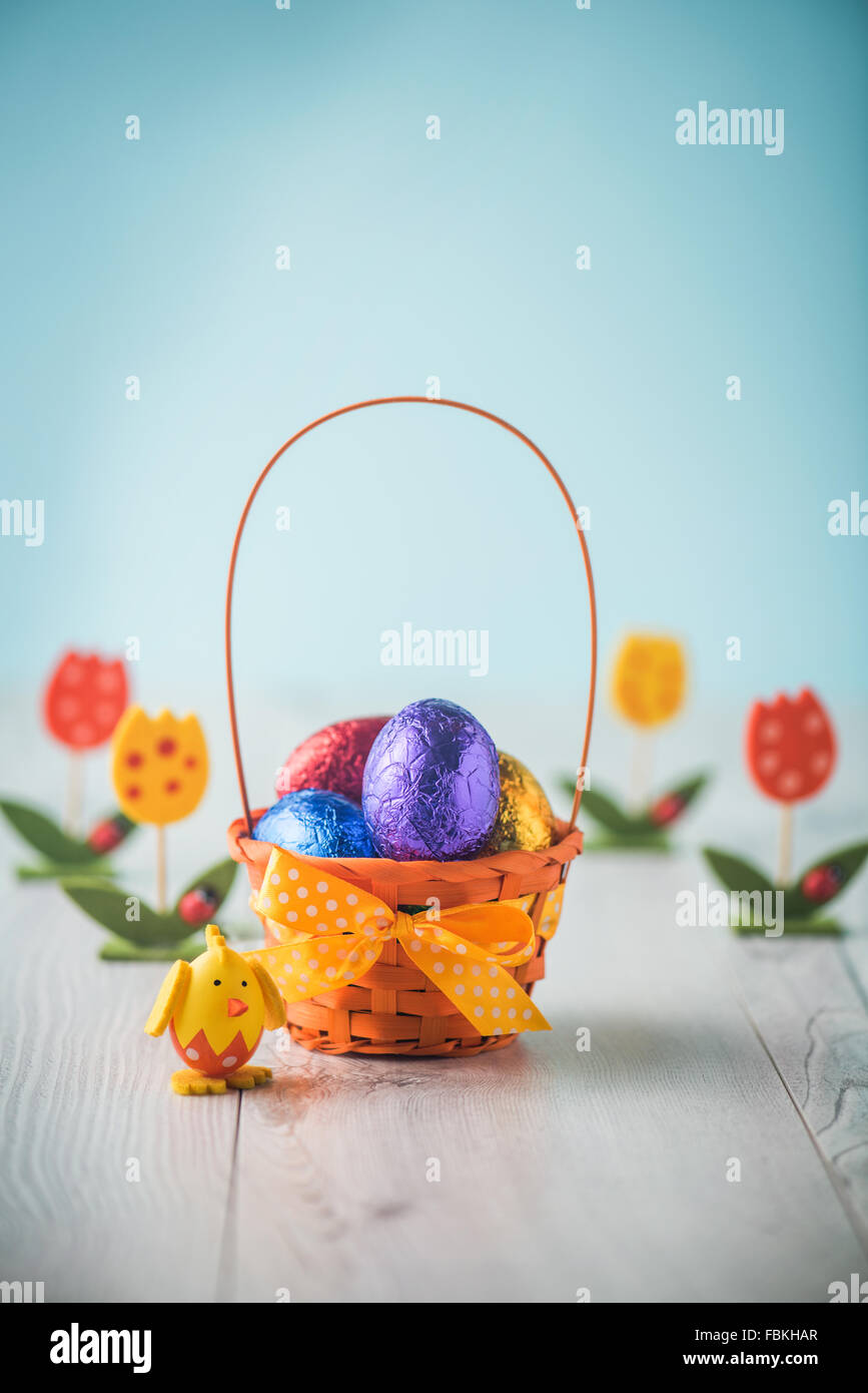 Color full easter eggs in a basket on a white table Stock Photo - Alamy