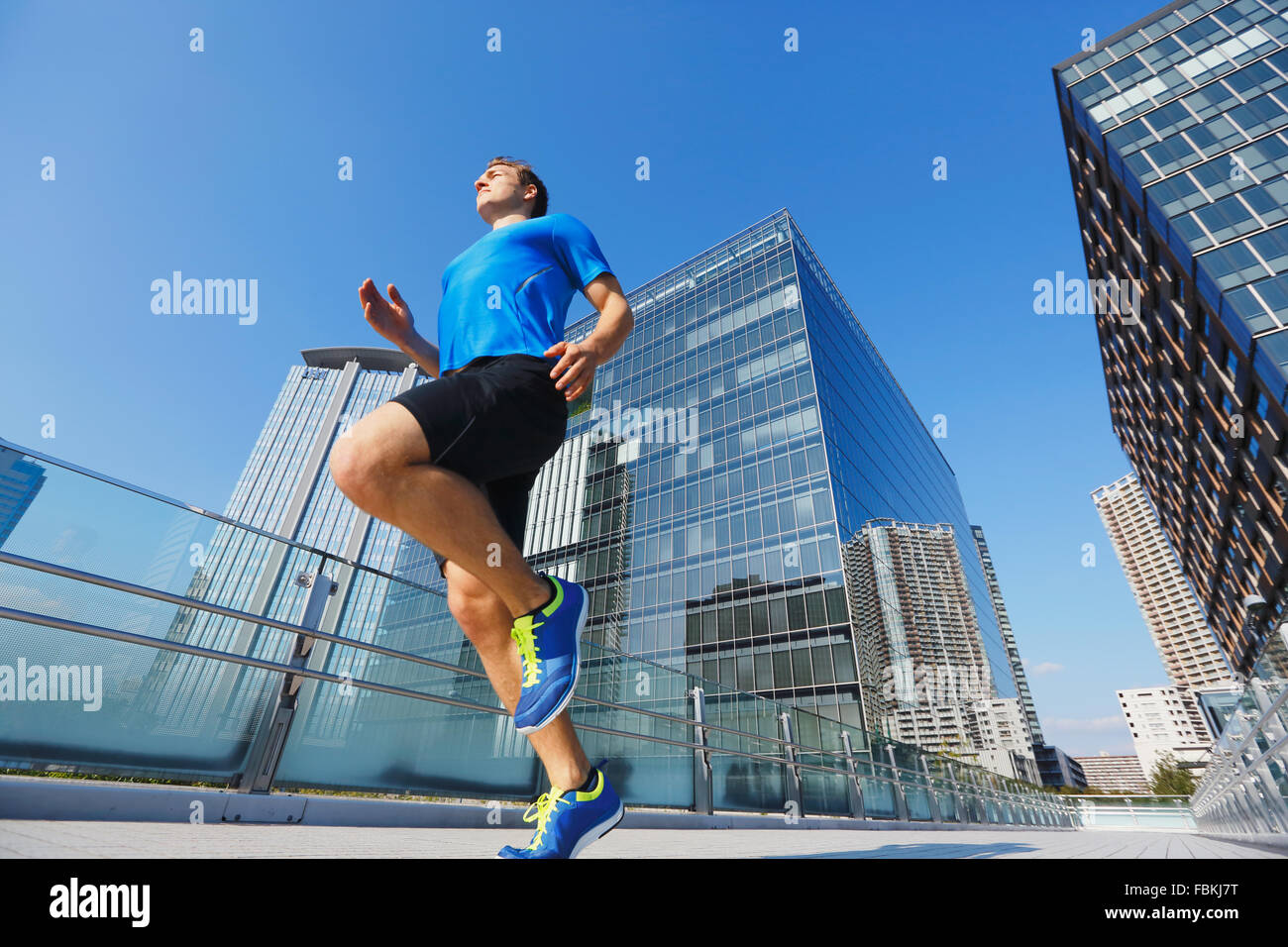 Young Caucasian man running in metropolitan area Stock Photo