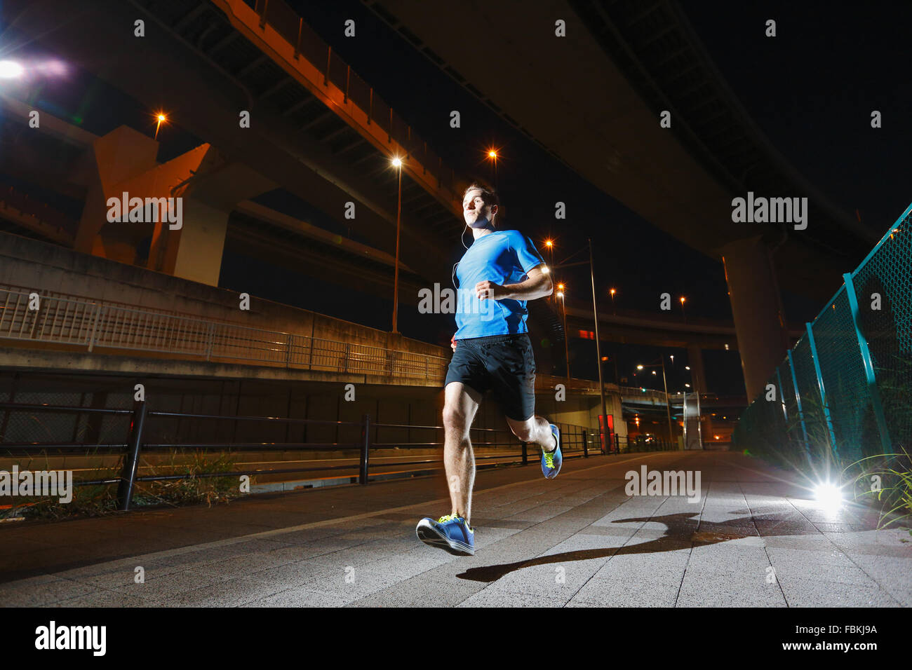 Young Caucasian man running in metropolitan area Stock Photo