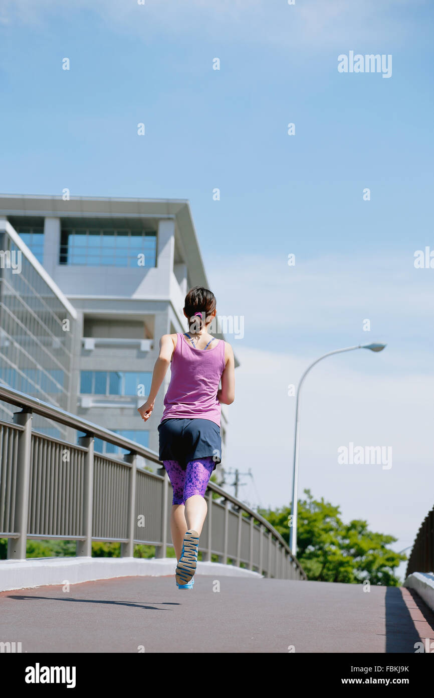 Young Japanese woman running downtown Tokyo Stock Photo Alamy