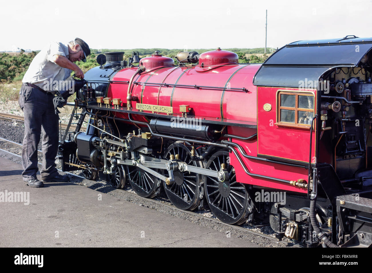 England, Kent, Dungeness. The driver tops up the oil levels in the miniature steam locomotive, 'Winston Churchill'. Stock Photo