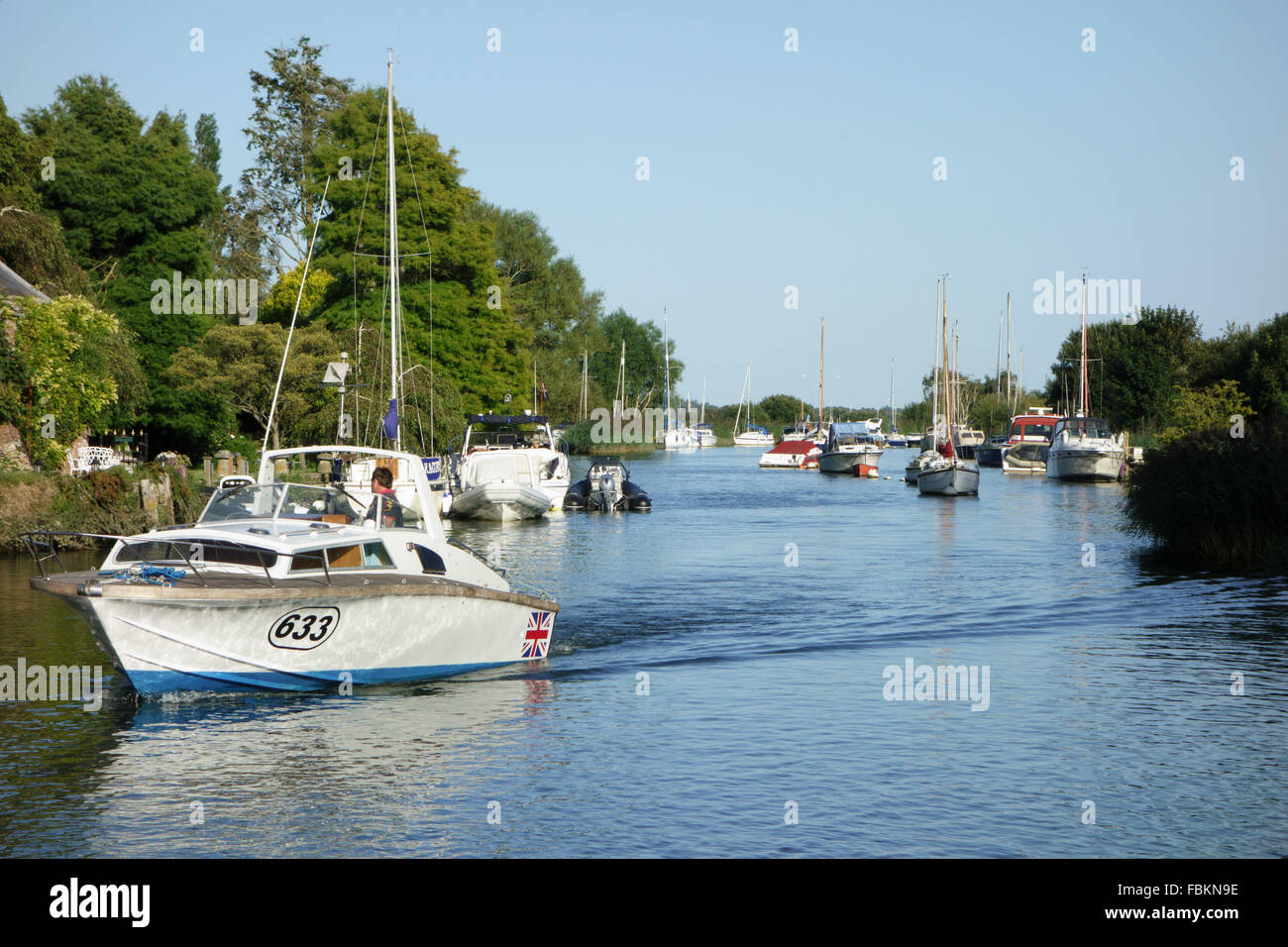 Boating on a mid-summer evening on the river Frome, Wareham, Dorset, England Stock Photo