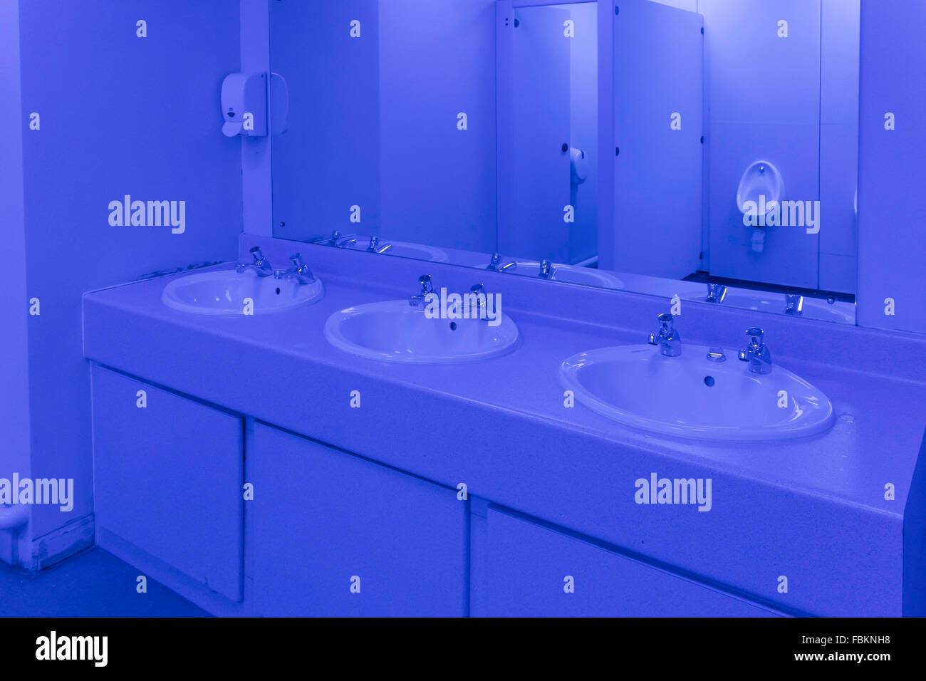 Washroom in a Gentlemen's Public Convenience lit with blue light to deter drug abuse by preventing users from seeing their veins Stock Photo