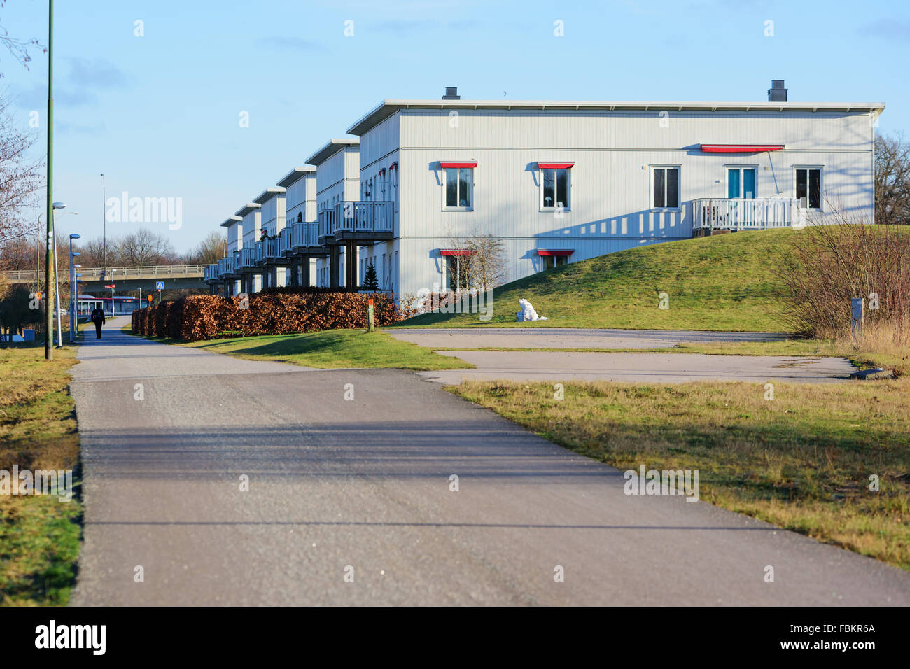 Karlskrona, Sweden - January 13, 2016: A row of modern residential buildings with a walkway in front. One person walk along the Stock Photo