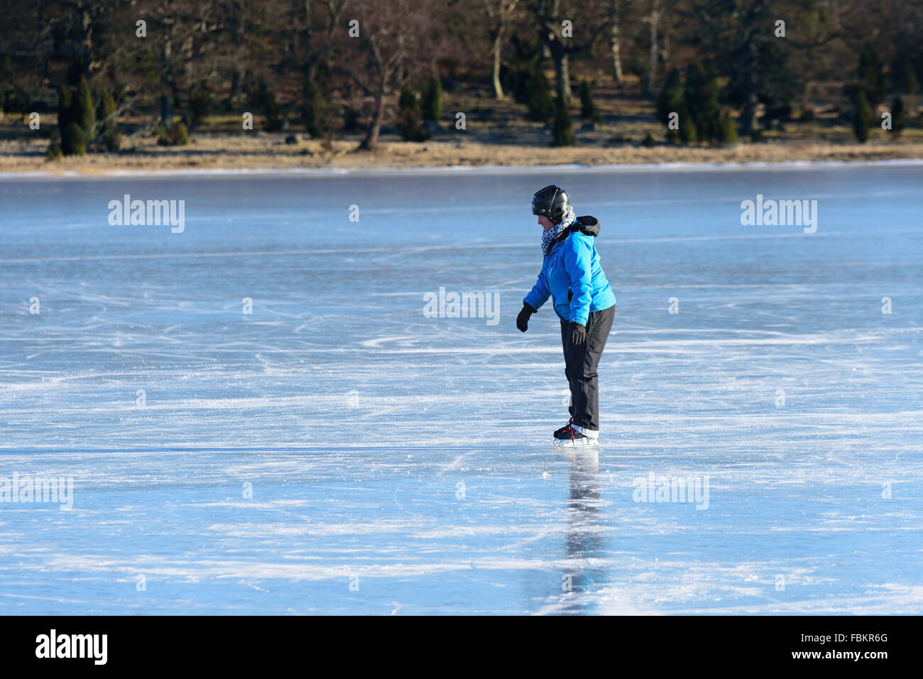 Listerby, Sweden - January 17, 2016: An unknown person is trying to skate on sea ice. The person looks a bit weary and uncertain Stock Photo