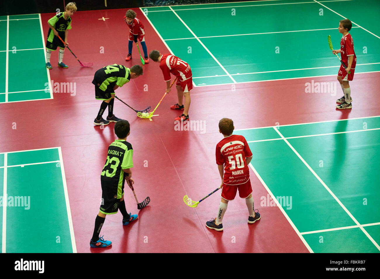 Children boys schoolchildren playing floorball (floor hockey) match in