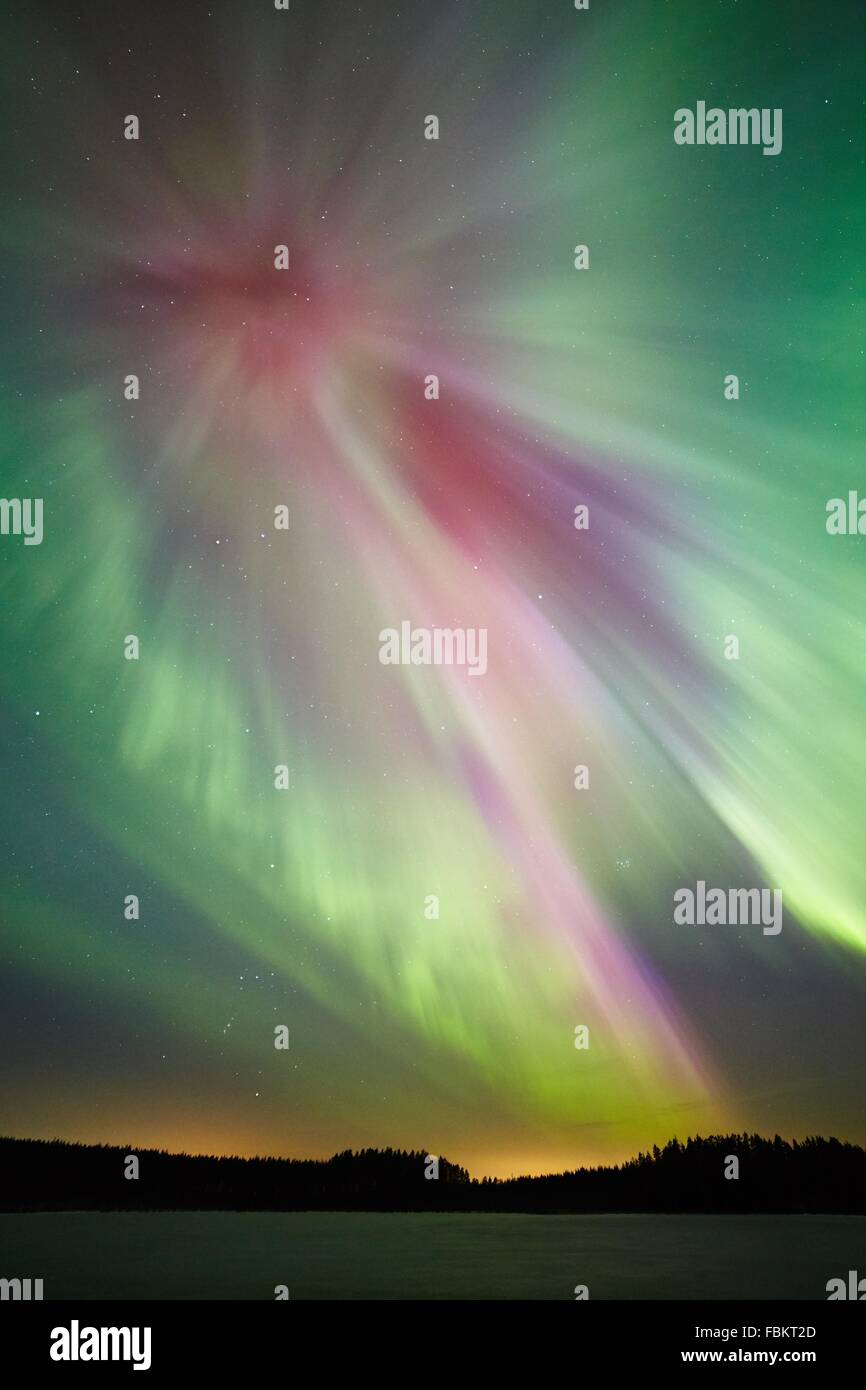 Northern lights (Aurora Borealis) glowing in the night sky over a icy ...