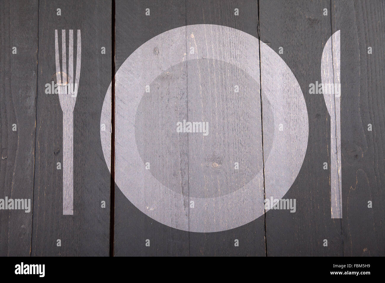 Illustration of white plate with fork and knife on dark black wooden background Stock Photo