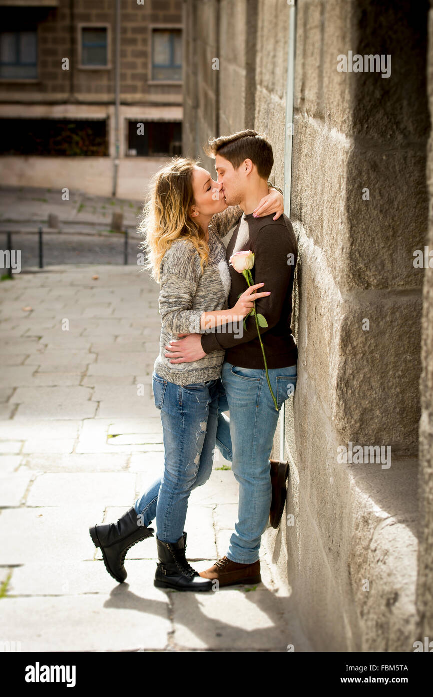 Candid Portrait Of Beautiful European Couple With Rose In Love Kissing