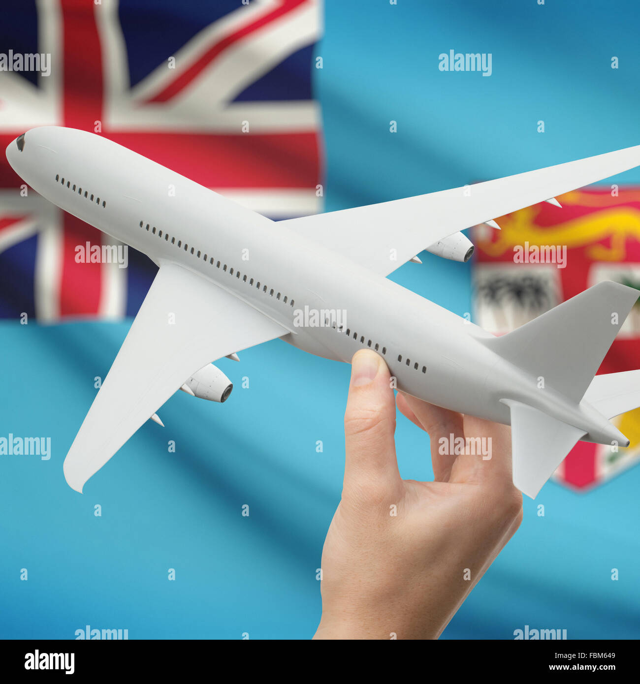 Airplane in hand with national flag on background series - Fiji Stock Photo