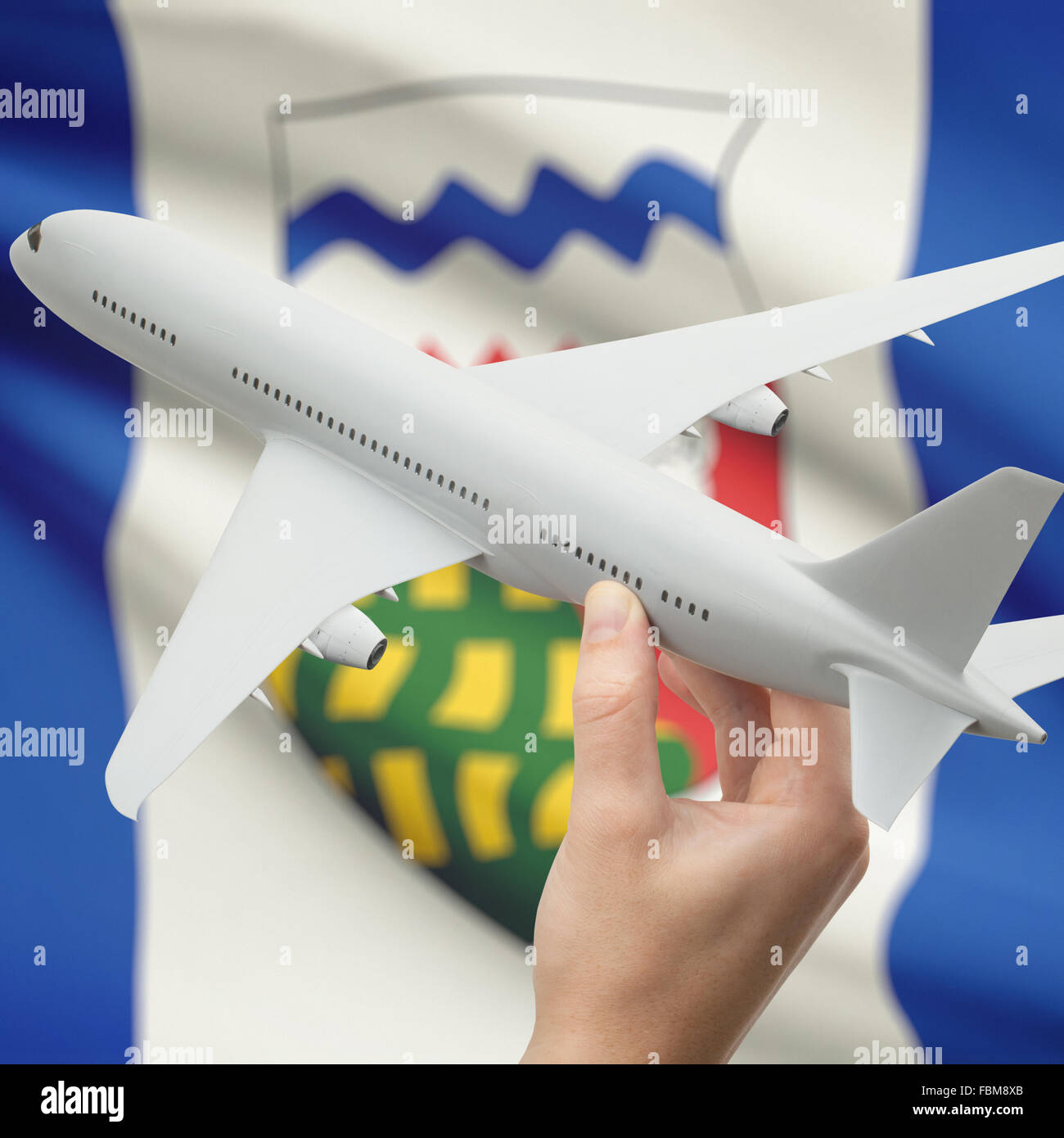 Airplane in hand with Canadian province or territory flag on background series - Northwest Territories Stock Photo
