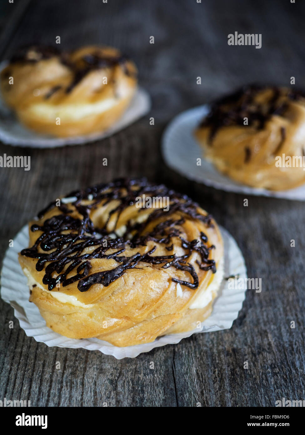 Three donuts on a wooden table Stock Photo