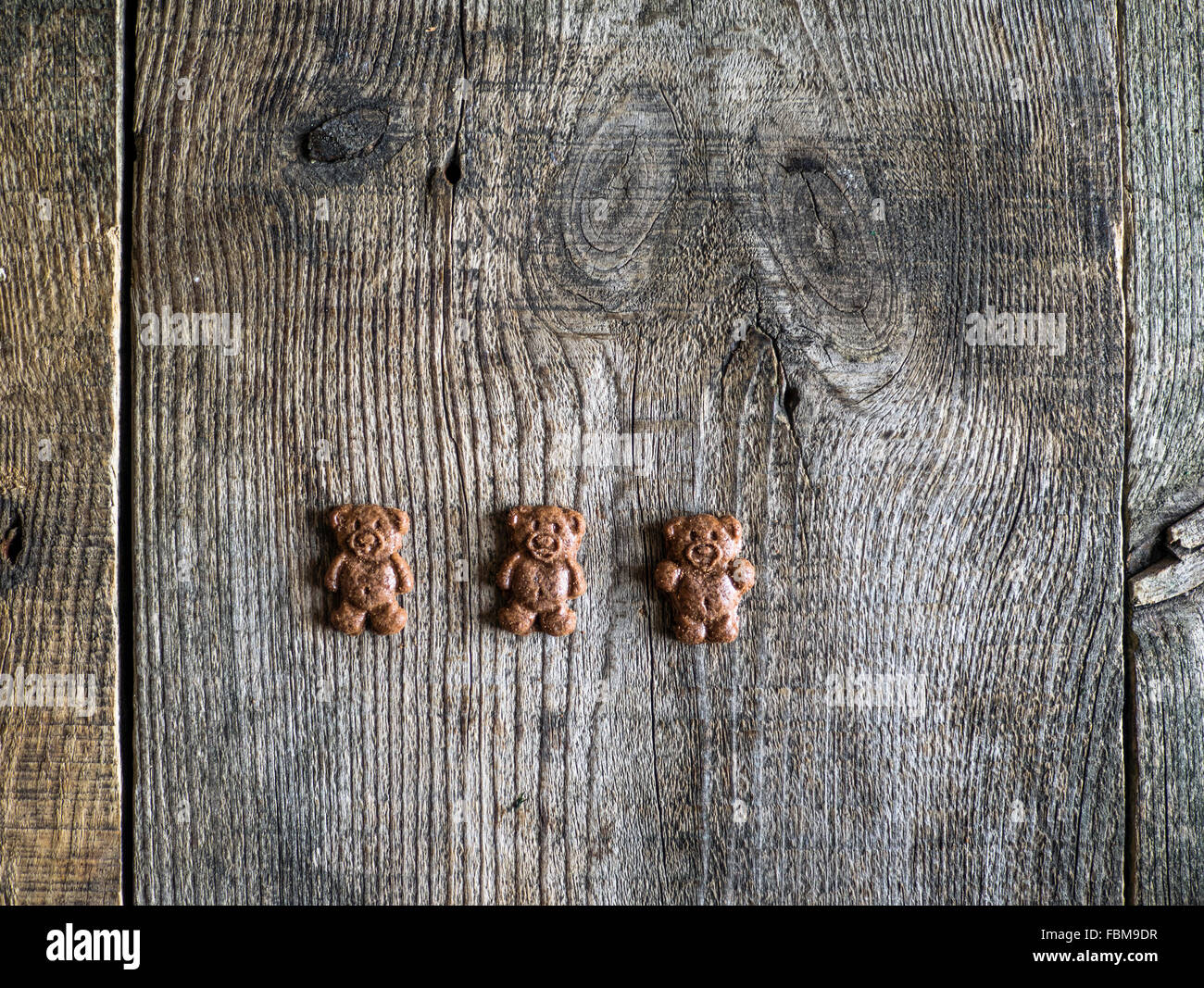 Three chocolate bear cookies on a wooden table Stock Photo