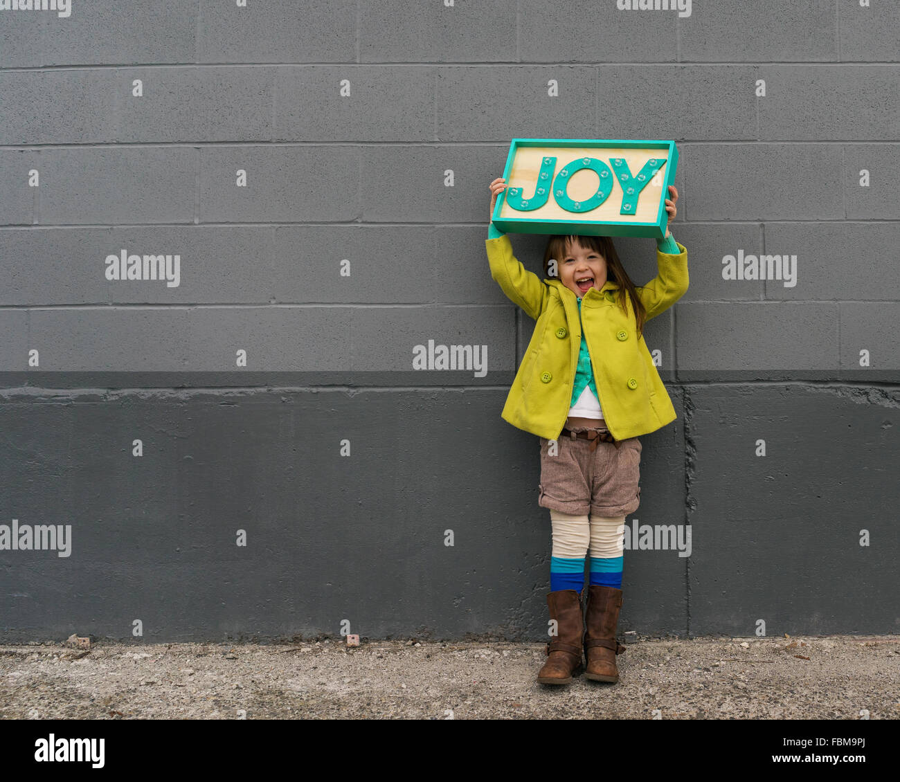 Happy girl holding a joy sign Stock Photo