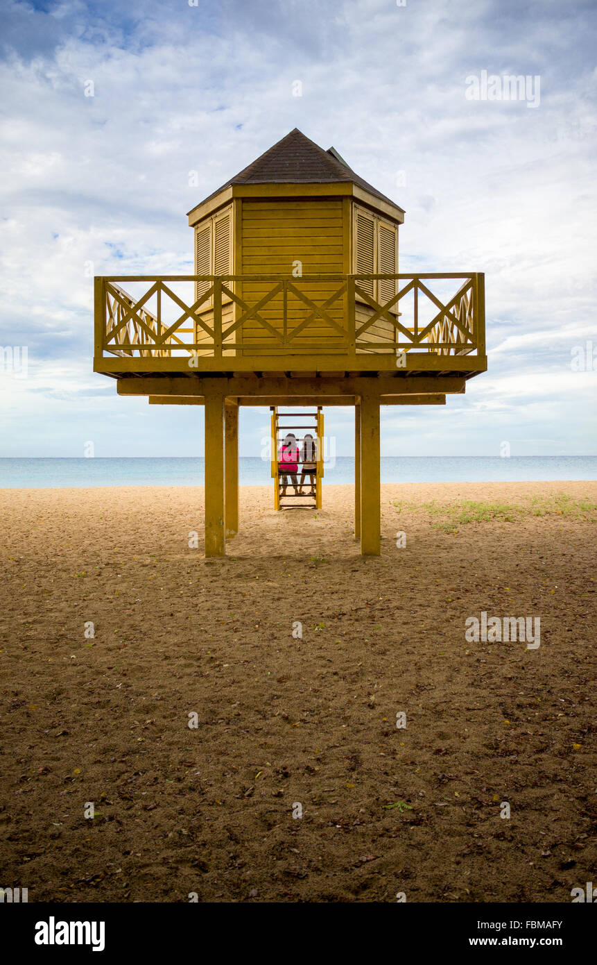 Two people sitting on steps of a lifeguard hut, Barbados, Caribbean Stock Photo