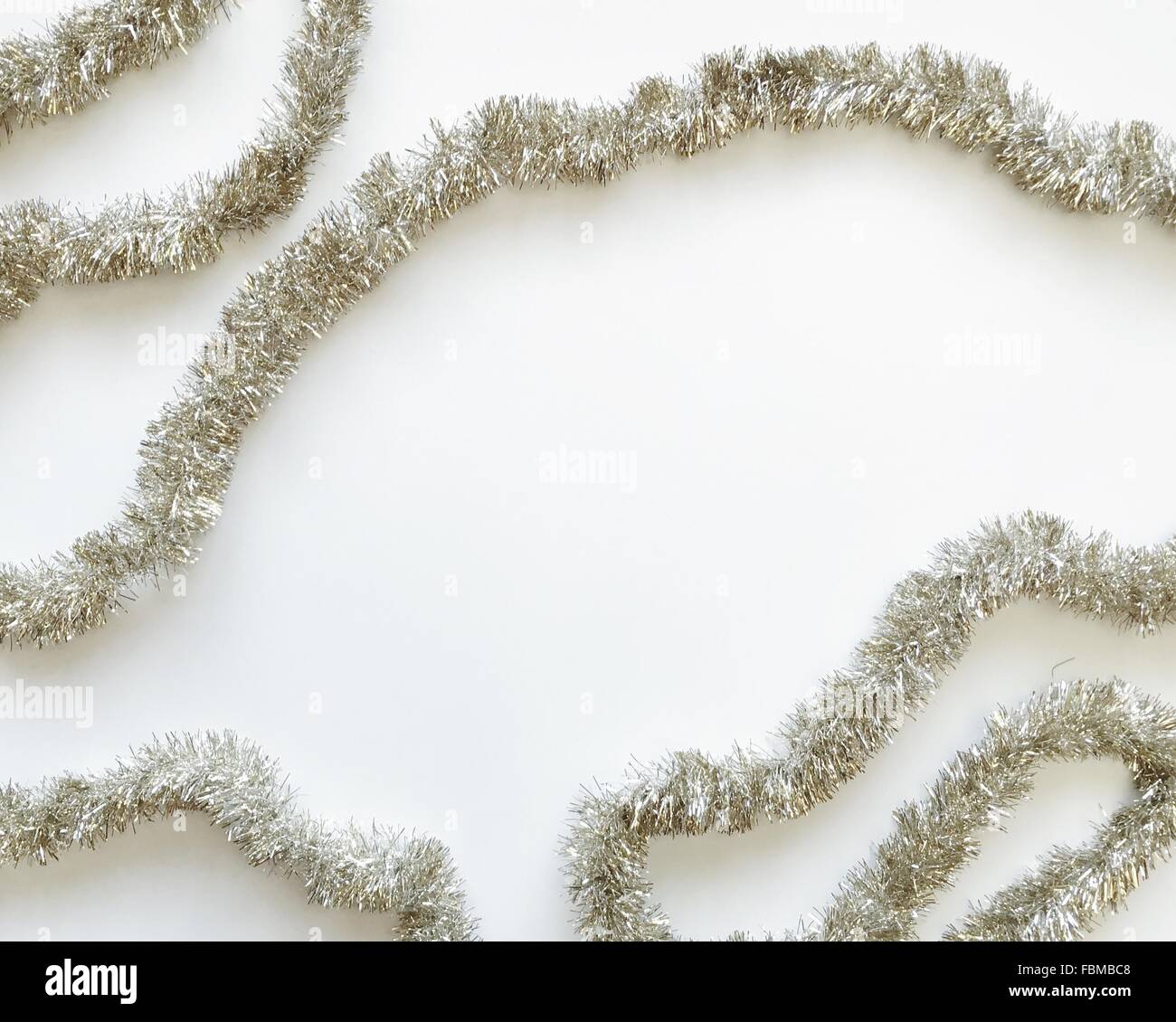 Silver tinsel on a white background Stock Photo Alamy
