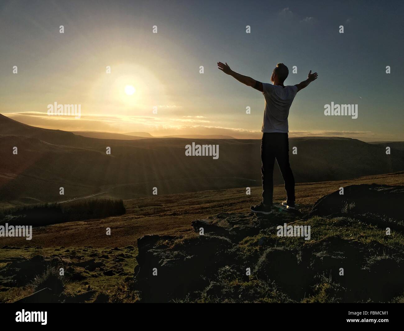 Man standing on mountain with arms outstretched Stock Photo Alamy