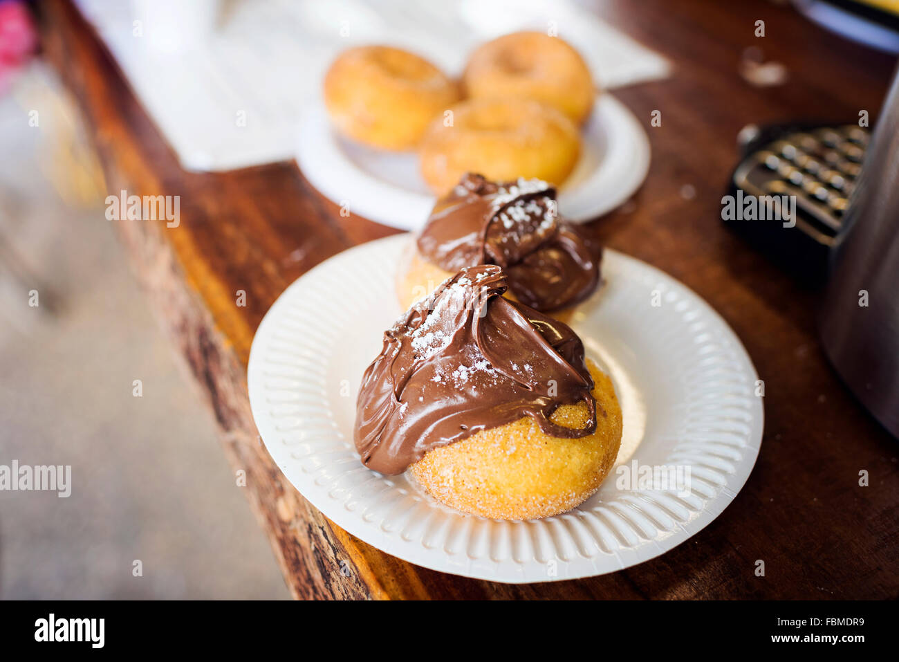 Cinnamon donuts covered in chocolate spread on a plate Stock Photo Alamy
