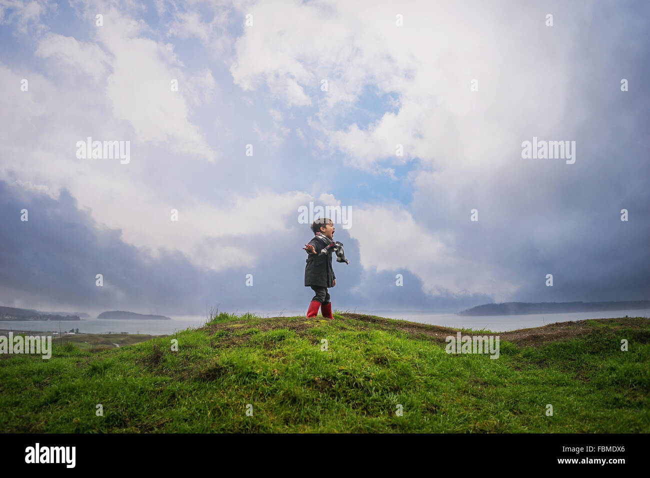 Boy standing on a hill shouting Stock Photo