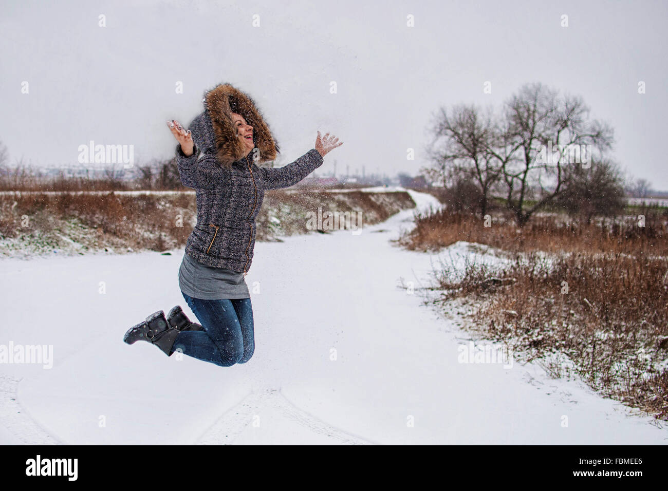 Mid adult woman jumping in the air Stock Photo