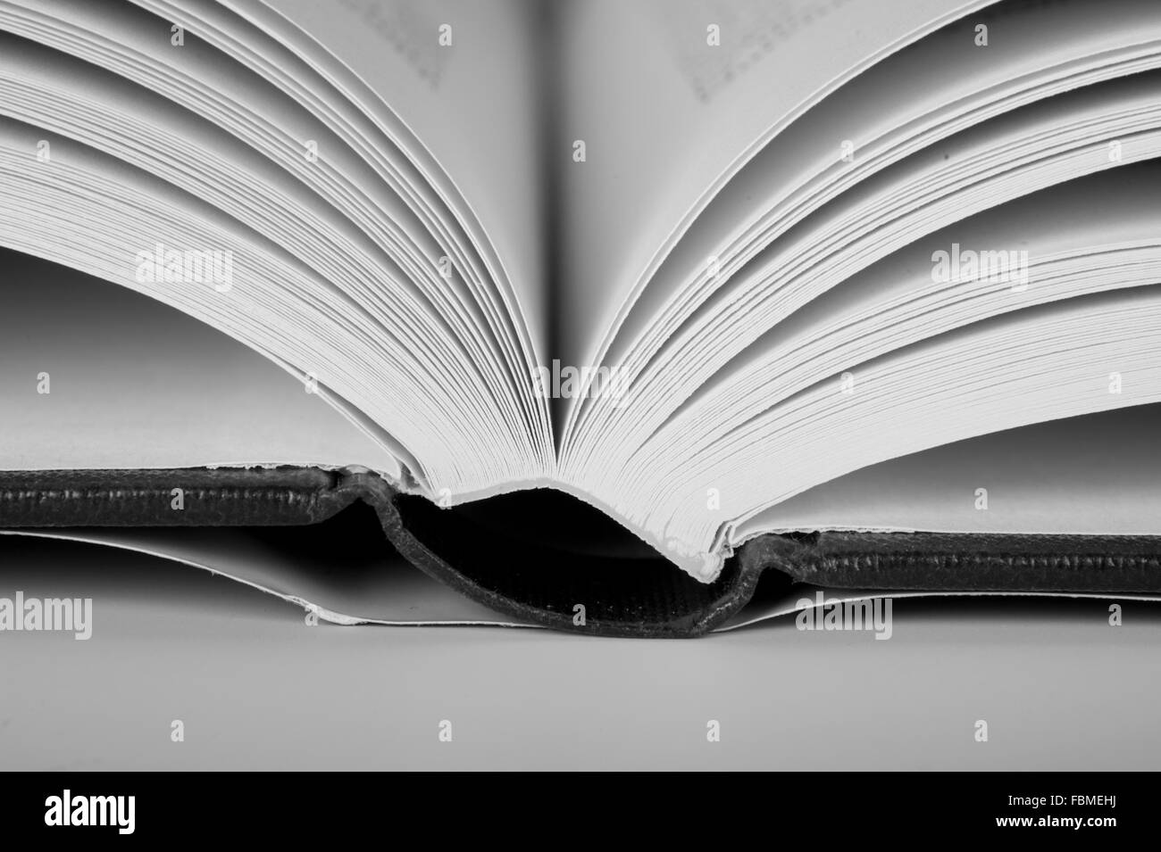 Open book spine resting on a table Stock Photo - Alamy
