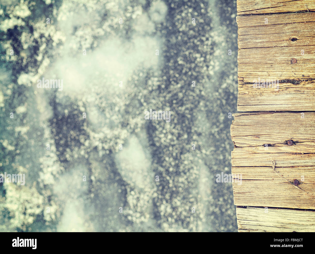 Retro toned old wooden pier on ice, abstract background. Stock Photo