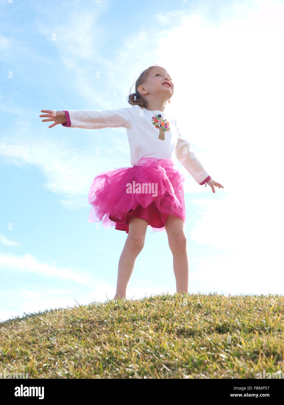 Girl Standing With Her Arms Outstretched Stock Photo