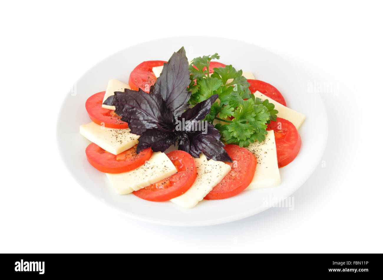 Tomatoes with Mozzarella and parsley and basil Stock Photo