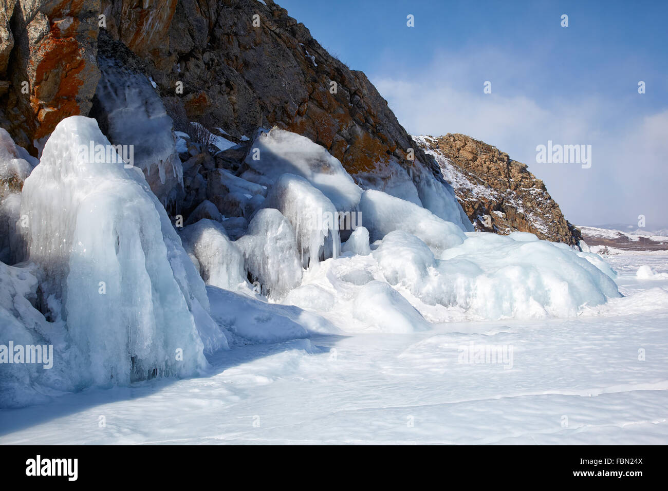 Rocks covered by ice on winter siberian Baikail lake under blue sky backgroun Stock Photo
